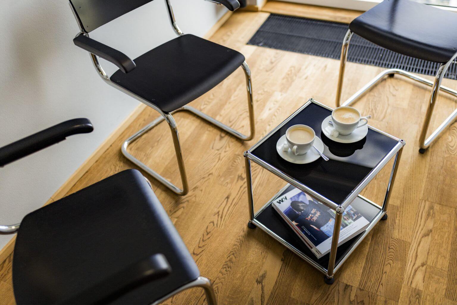 Stühle und kleiner schwarzer Tisch mit zwei Kaffeetassen